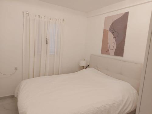 海法דירת נופש על הים בחיפה的一间白色的卧室，配有一张白色的床和一扇窗户