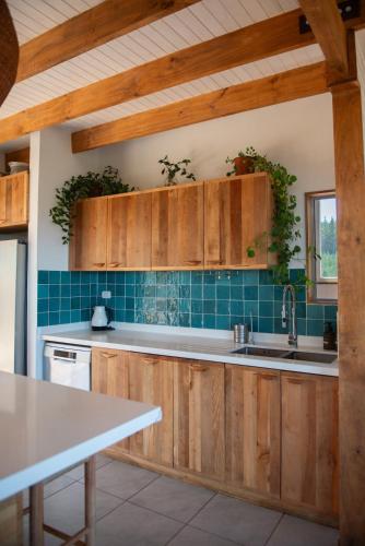 a kitchen with wooden cabinets and a sink at Casamar Retreat Buchupureo in Buchupureo
