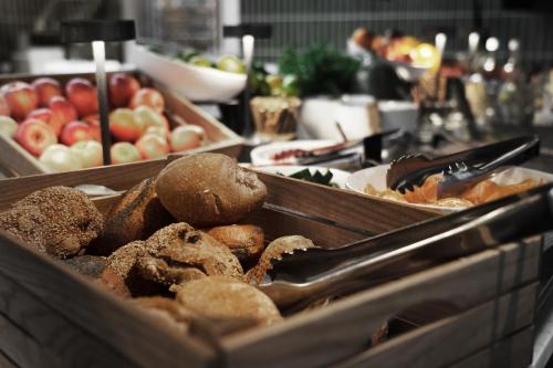 Una bandeja de panes y manzanas sobre una mesa. en Hotel Ottilia, en Copenhague