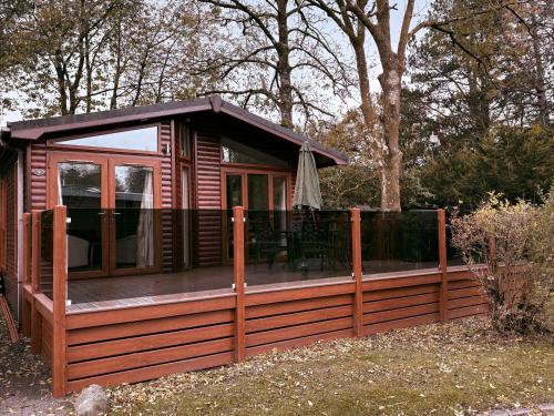 a large wooden cabin with a wooden deck at Coniston Number 9 in Troutbeck Bridge