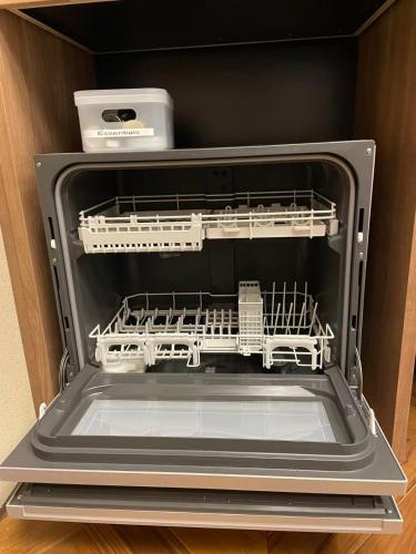 an empty dishwasher with its door open with its door open at Basara Kinmokusei 金木犀Kyoto Machiya in Kyoto