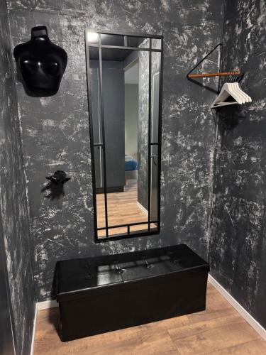 a black bathroom with a mirror and a black tub at Loft apartment in Kouvola