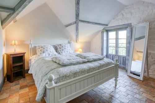 Un dormitorio con una cama y una ventana grande. en Le Gîte du Château Fouquet - Piscine privée, en Brézé