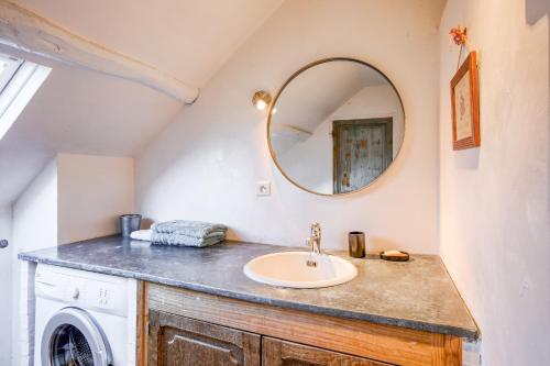 un baño con lavabo y espejo en Le Gîte du Château Fouquet - Piscine privée, en Brézé