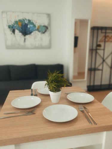 a wooden table with white plates and a plant on it at GO&REST Apartments in Valencia