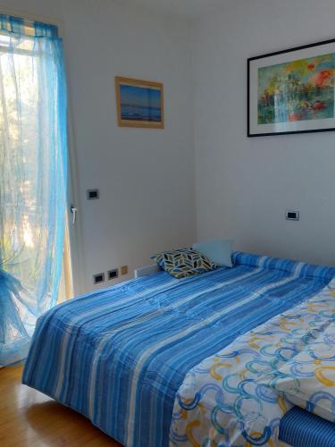 a bedroom with a bed with a blue comforter at Appartamento Le Nuvole da Davide e Romina in Santarcangelo di Romagna