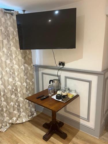 a table with a flat screen tv on a wall at The Dublin Packet Room No6 in Holyhead