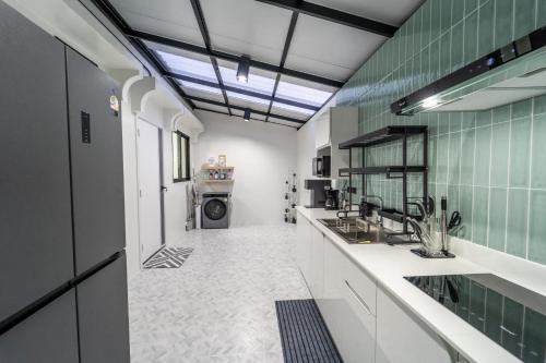 a kitchen with a sink and a washing machine at Stylish 3 Bedroom Villa with Garden, Chalong - by PoshSaga in Chalong 