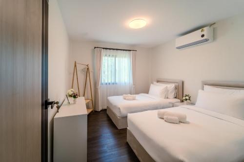 a hotel room with two beds and a window at Stylish 3 Bedroom Villa with Garden, Chalong - by PoshSaga in Chalong 