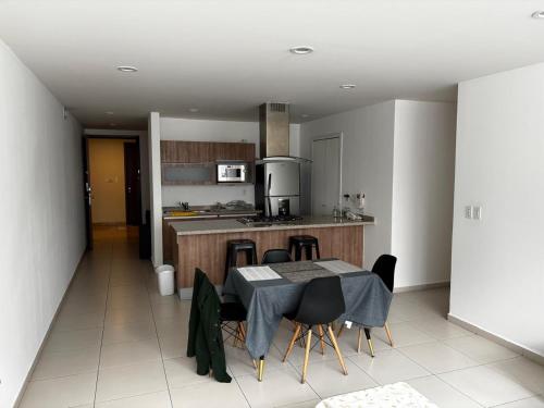 een keuken met een tafel en stoelen in een keuken bij torre renoir 96, depto 306 in Mexico-Stad