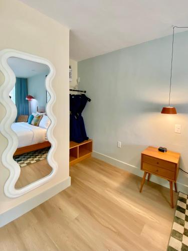 a bedroom with a mirror with a bed and a table at Gainesville Lodge in Gainesville
