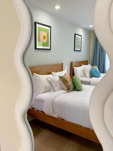 two beds in a room with white sheets and pillows at Gainesville Lodge in Gainesville