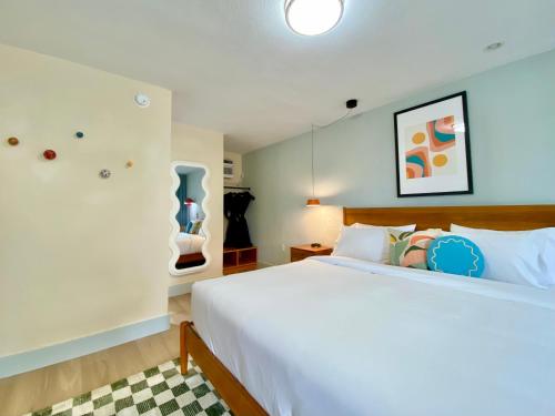 een slaapkamer met een groot wit bed in een kamer bij Gainesville Lodge in Gainesville