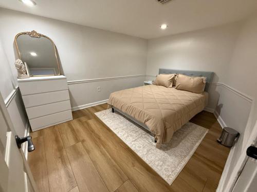a small bedroom with a bed and a mirror at Modern loft 9 min from EWR in Hillside