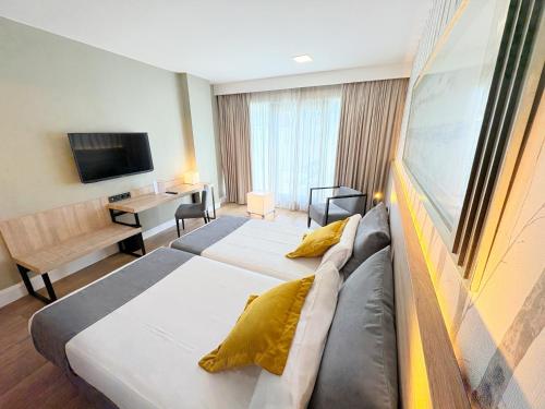 a hotel room with two beds and a television at Eurohotel Barcelona Granvia Fira in Hospitalet de Llobregat
