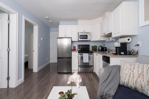 a kitchen with white cabinets and stainless steel appliances at 2 bedroom suite Walk to SkyTrain, Grocery, Macdonald & more in Vancouver