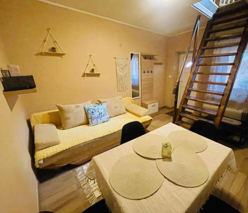 a room with a bed and two tables and a staircase at Bükk-Völgye Apartman in Bogács