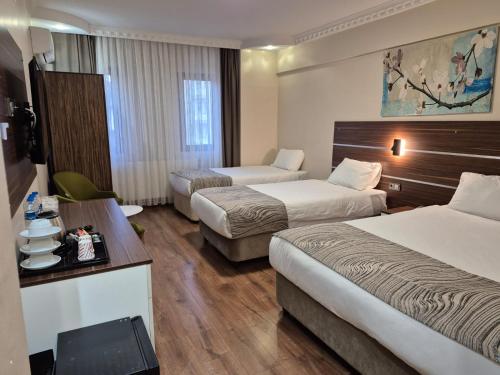 a hotel room with two beds and a table at BEYAZ İNCİ OTEL in Sivas