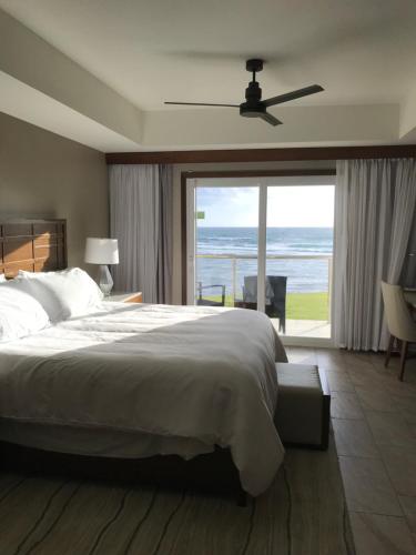 Un dormitorio con una cama con vista al mar. en Dawn Beach JW Marriott, en Oyster Pond