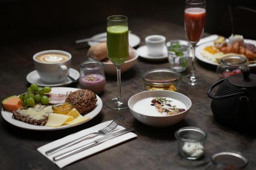 a table with plates of food and glasses of drinks at Apartments by Brøchner Hotels in Copenhagen