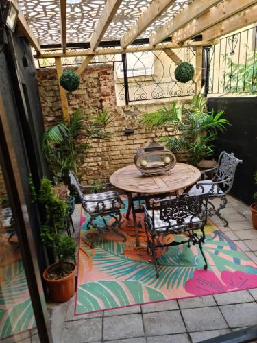 a patio with a table and chairs on a rug at Seaside hideaway st Leonards in Hastings