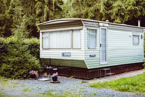 a green and white trailer parked in a yard at Retro mobilehome Fanfare Woltzdal in Bischenrech