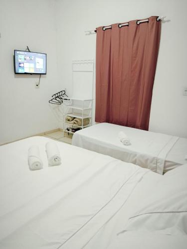 2 letti in una camera con tenda rossa di Micro Casas, Próximas ao Terminal Rodoviário, Mercado de São Brás - 1 Unidade disponível para COP 30 a Belém
