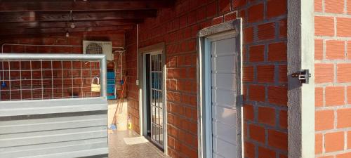 a brick building with a door and a window at Depto alem in Leandro N. Alem