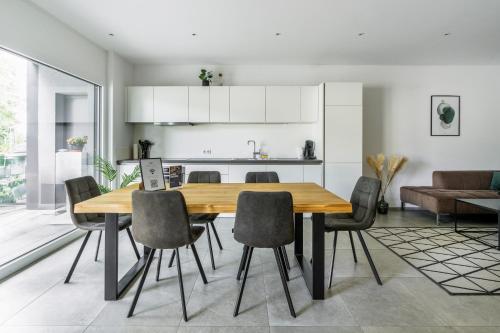 フェルトキルヒにあるhomy City Diamant in Feldkirch, Grenznähe und doch Zentralの木製のテーブルと椅子のあるキッチンとダイニングルーム