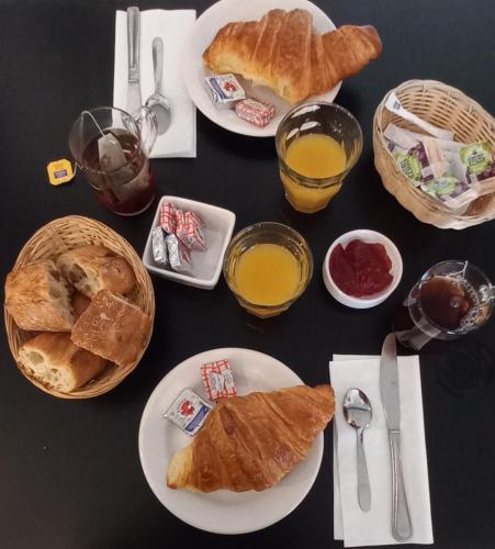 einen Tisch mit Brotplatten und Gläsern Orangensaft in der Unterkunft Unique et Insolite Bus Iliade in Bourg