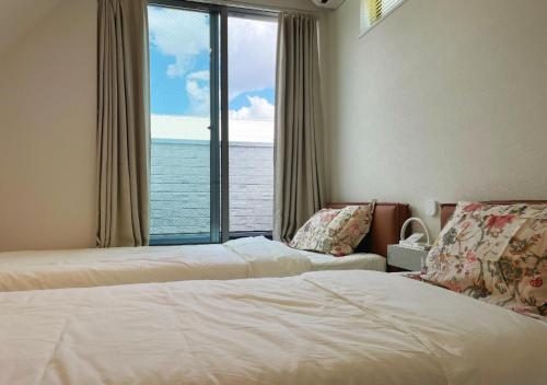 a hotel room with two beds and a large window at 大阪第一站 in Osaka
