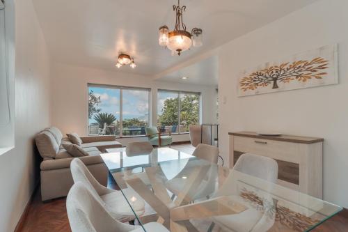 a living room with a glass table and chairs at Villa Natural Oasis with panoramic view & bio-diverse 9 950m2 garden in Funchal