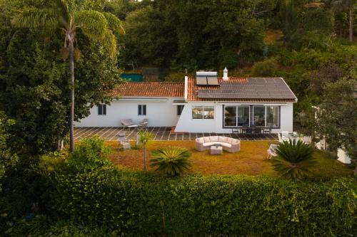 a small white house with a garden in front of it at Villa Natural Oasis with panoramic view & bio-diverse 9 950m2 garden in Funchal