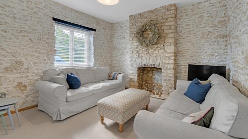 a living room with two couches and a fireplace at Japonica in Minster Lovell