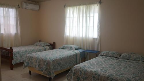 Un dormitorio con dos camas y una ventana. en Sunrise Santa Catalina, en Santa Catalina