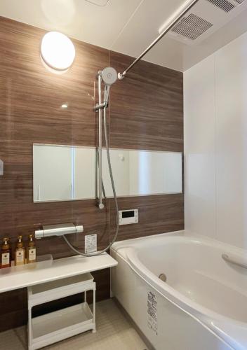 a bathroom with a tub and a sink and a mirror at 大阪第一站 in Osaka