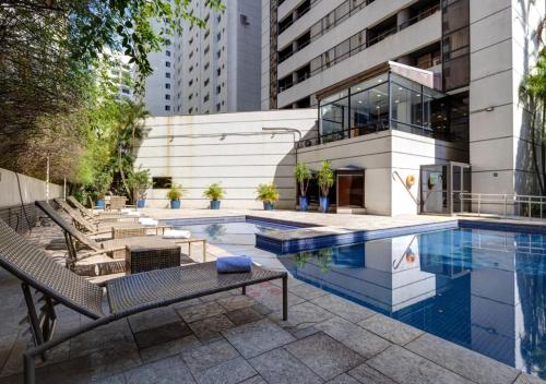 a swimming pool in front of a building at Quality Paulista (São Paulo, Jardins) in Sao Paulo