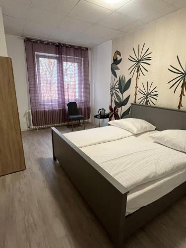a bedroom with a large bed and a chair at Art Rock Airport in Cologne