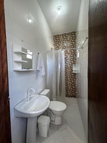 a white bathroom with a sink and a toilet at Pousada e hostel Costa do Sol Coroa Vermelha in Porto Seguro