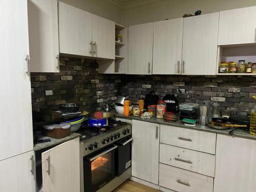 una cucina con armadi bianchi e forno di Your Palace ad Addis Abeba