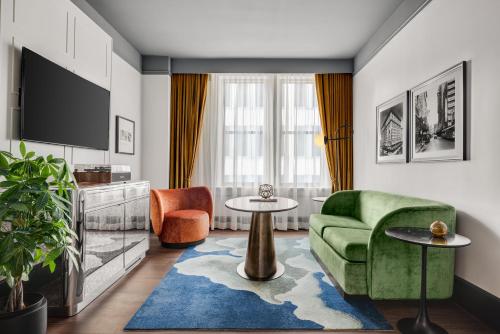a living room with a green couch and two chairs at The Gunter Hotel San Antonio Riverwalk in San Antonio