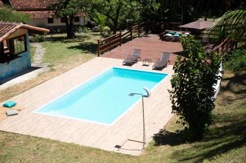 einen Pool im Garten mit Holzterrasse in der Unterkunft Sitio Novo Dia in Saquarema