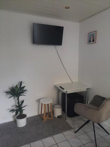 a room with a desk and a table and a chair at Zimmer mit eigenem Bad und eigenem Eingang in Bad Oeynhausen