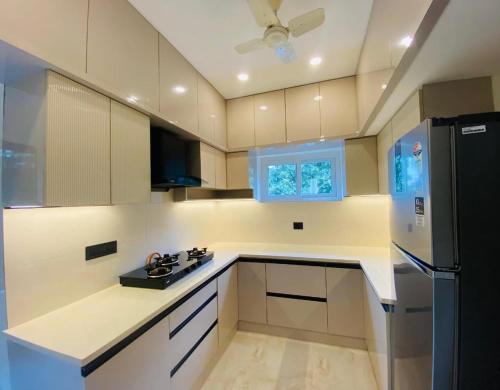 a kitchen with white counters and a refrigerator at Family 3 BHK Residency Top Spots, Falnir Mangalore in Mangalore
