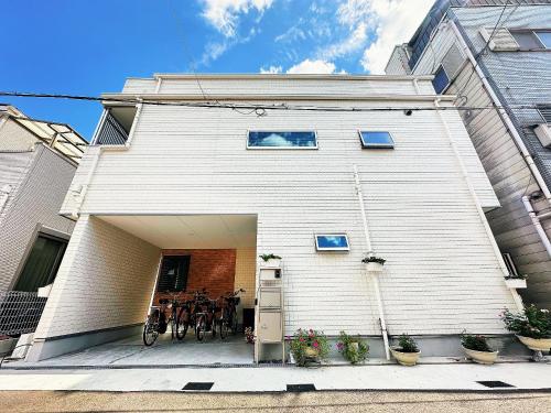 a white house with a table in the garage at 大阪第一站 in Osaka