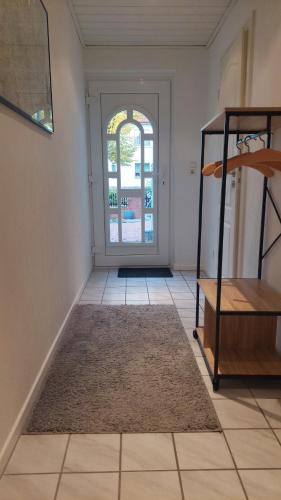 a hallway with a door to a room with a rug at Zimmer mit eigenem Bad und eigenem Eingang in Bad Oeynhausen