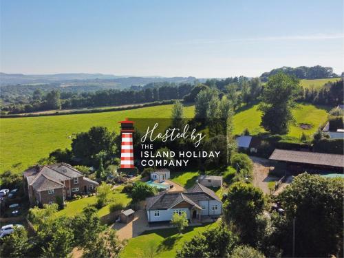 an aerial view of a house with a barn and a field at Adgestone Villa - A Luxurious Countryside Escape with Heated Pool, Near Sandown Beach, Dog Friendly in Rural Sandown - Perfect Getaway for Family & Friends in Alverstone