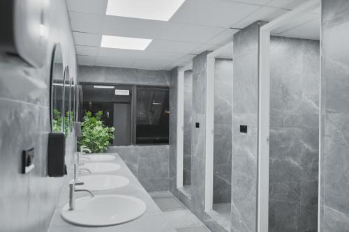 a bathroom with four sinks and a row of toilets at Kinboshi Silom in Bangkok