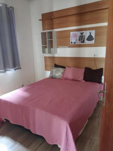 a bed in a room with a pink blanket at Casa Andreia Borges in Aparecida de Goiania