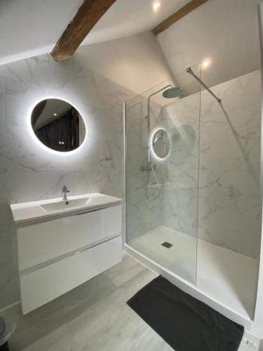 a white bathroom with a sink and a shower at Les maisons des Frangines in Oinville-Saint-Liphard